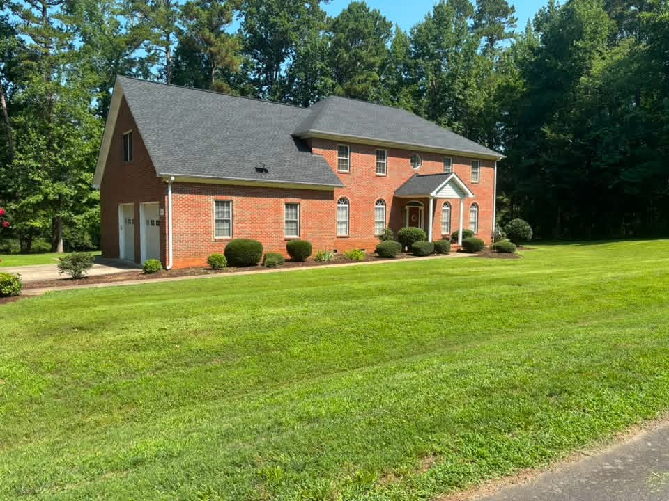 Beautifully maintained lawn and landscape in front of a brick home